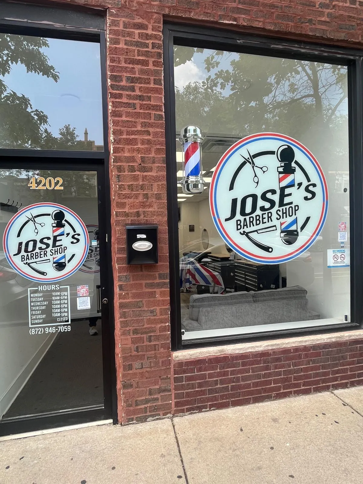 The brick storefront of Jose's Barber Shop on N Milwaukee Ave in Portage Park, Chicago, with the logo on the window and a spinning barber pole